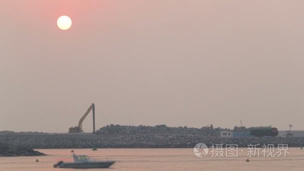 放松在迪拜朱美拉海滩附近的日落。平静的大海和船轻松的在迪拜游戏中时光倒流