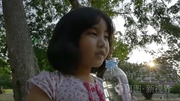 在公园里的小亚洲孩子喝水视频
