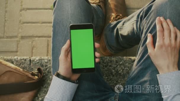 Man is Using Phone on Lap Outdoors at Sunny Day. POV