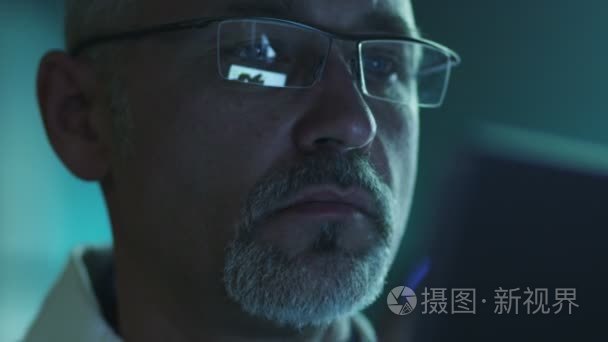 中间岁男性在眼镜中使用平板电脑和屏幕有思考的肖像