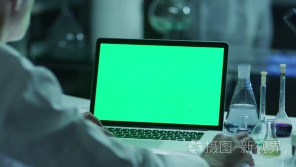 Scientist is using Laptop with Green Screen in Laboratory. Great