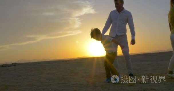 父母和儿子在日落时跳舞