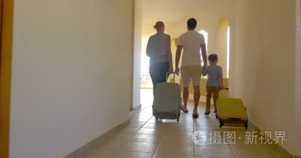 Family of three with roll-on bags in hotel