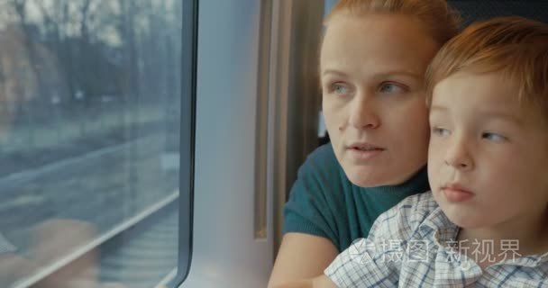 Mother and son looking out train window