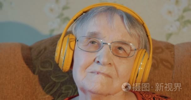 Elderly woman listening to music in headphones