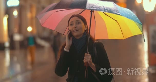 手机上的雨天街上的黑发女人谈视频