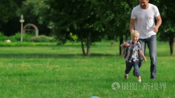 父亲和儿子玩球在公园里