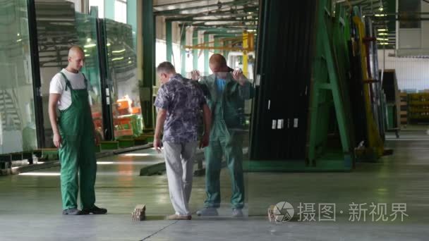 Two Workers in Green Uniform  Holding the Sheet of Glass  Man in