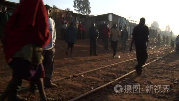 People stand near train tracks