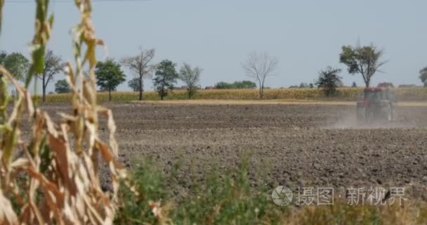 拖拉机遥遥是春耕外地黑土壤飞尘埃背后拖拉机路沿外地车上道路树木玉米秸秆对前景