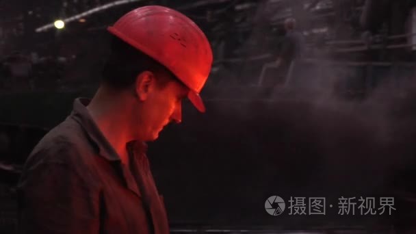 工人们正在测量厚度的金属板橙色的热金属板工人男性在头盔安全头盔厂标志