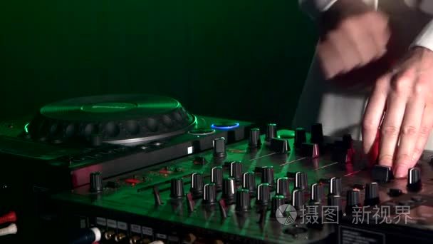 Dj hands on equipment deck  dancing and playing  close up  green