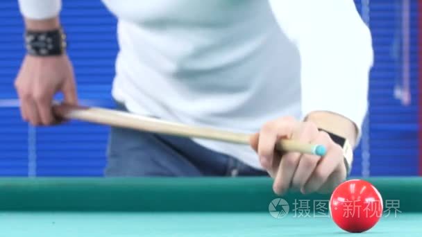 Guy takes aim, to make an impact on a billiard ball