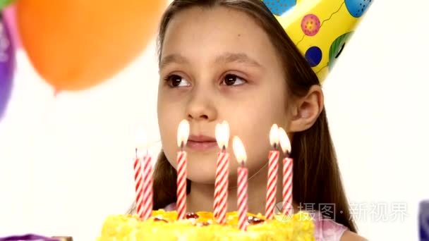 Birthday girl blows out  candles on a birthday cake. In the back