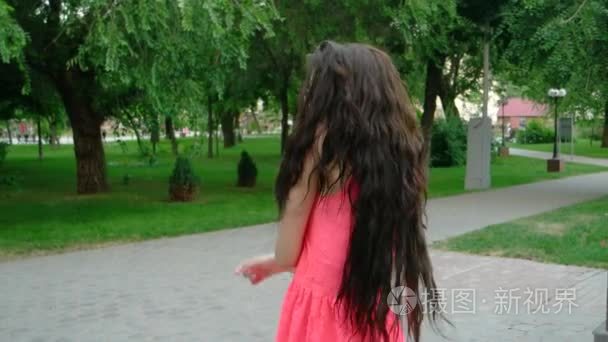 年轻漂亮的长卷发女人跳舞户外视频