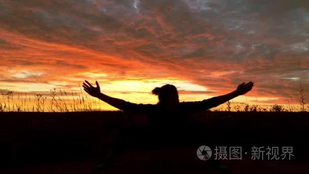 一个女孩知道空手道。在日落时做的裂痕从脚