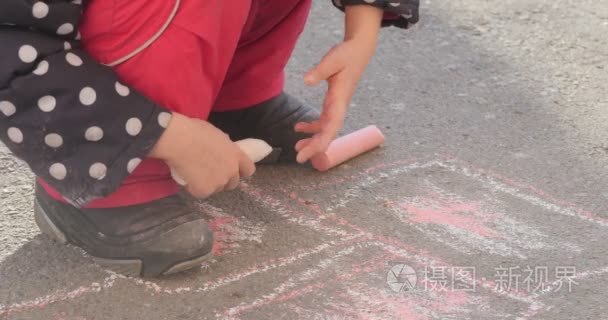 波尔卡圆点的靴子图片上沥青，女童手两地夹住粉笔轮流拿水桶与粉笔粉色的裤子外套