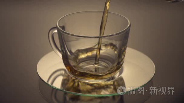 绿茶被倒入玻璃茶杯