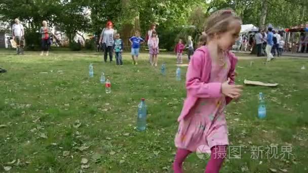 Girl Play Game Run Around The Bottles On The Grass