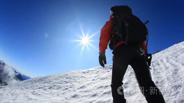 登山者攀登白雪皑皑的山脊视频