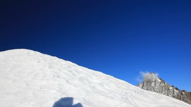 登山者攀登白雪皑皑的山脊视频