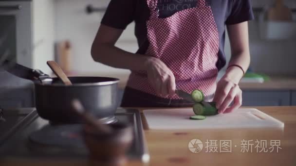 年轻的女孩在厨房里做饭的围裙视频