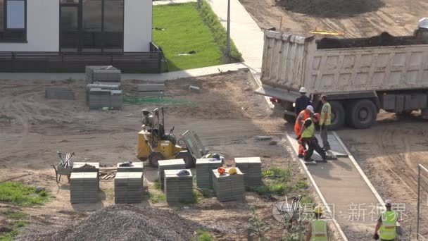 worker lay cement tiles near new building backyard . 4K