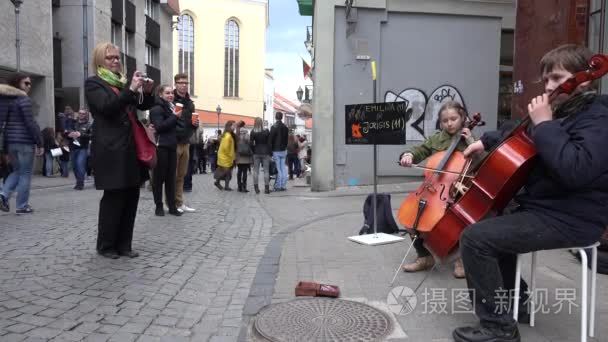 Young brother and sister play with violoncello at street. 4K