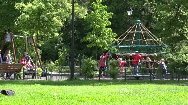 kids play in playground with rope swing carousel . 4K