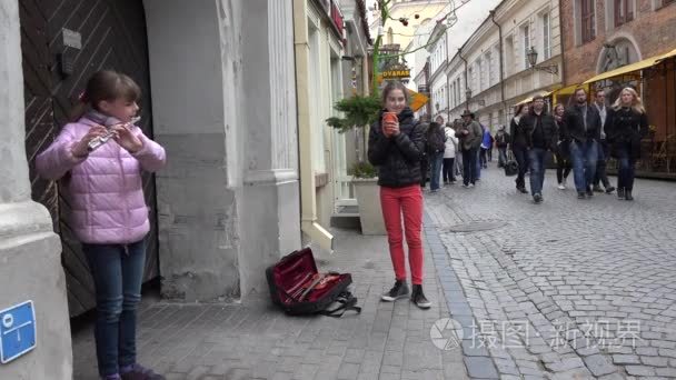 Girl play with flute fife pipe in street event people bypass. 4K