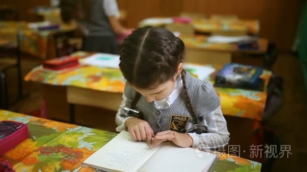 女孩青少年阅读本书女生坐在桌子前课室的学校