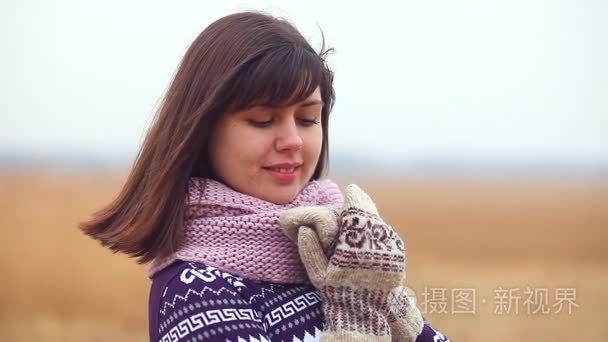 在毛衣围巾和手套在自然秋冷干草地上的女孩女人画像视频