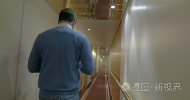 Adult Man Walking Along A Corridor Of Ocean Cruise Ship