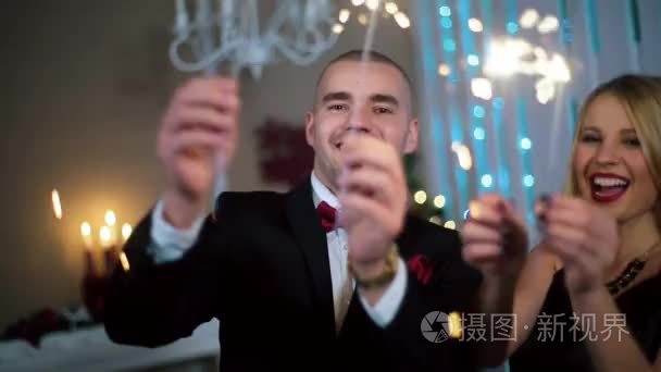 a Man in a Black Suit and a Woman in Evening Black dress waving 