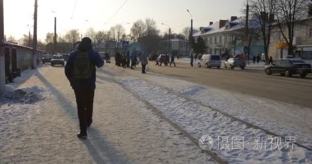 人是步行沿电车在 Konotop 市雪在地面车，车站在乌克兰是开车沿着街寒冷的冬天