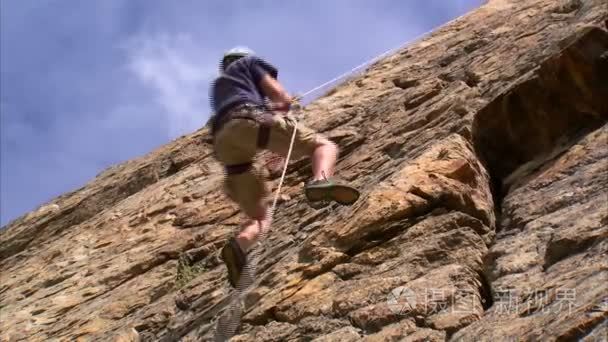 登山者爬上悬崖视频