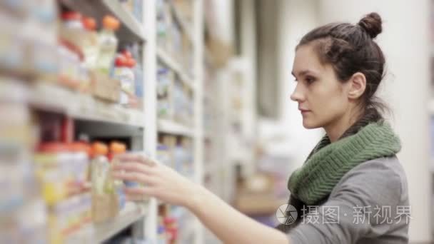年轻女人在超市选择婴儿食品