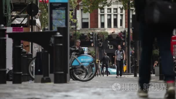 在 Soho 广场在人行道上行走的人