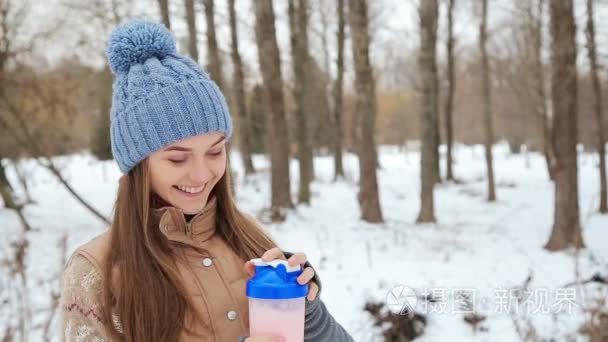 在冬季公园的美丽女孩蛋白饮料视频