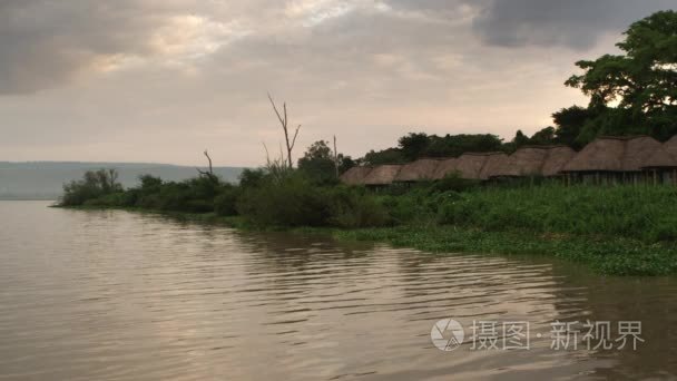 行的草屋顶住宅沿湖视频