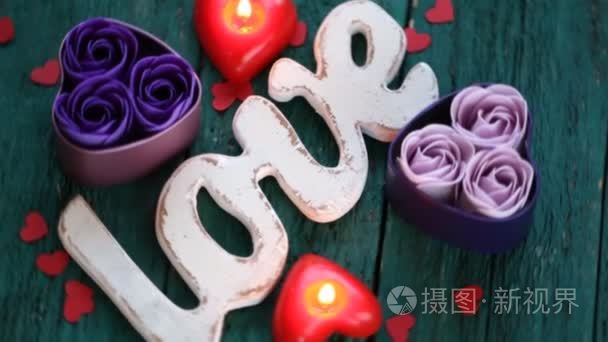 心的形状与木制背景上的蜡烛的红玫瑰。情人节的概念。爱情和浪漫