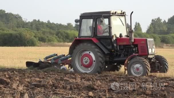 Farmer plow stubble field with red tractor. Panorama. 4K