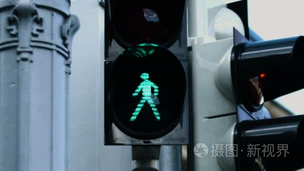 交通灯在白天时绿色灯开始闪烁在它之前的特写图片变为红色的符号，并警告行人