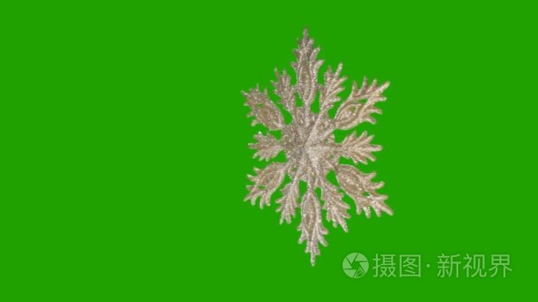 点缀在绿色背景上的雪花形成的视频