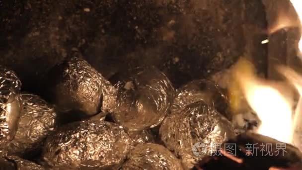 铝箔在壁炉里的余烬烘土豆包裹视频