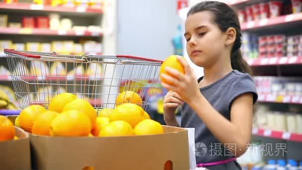 女孩与平板电脑在超市买橙色