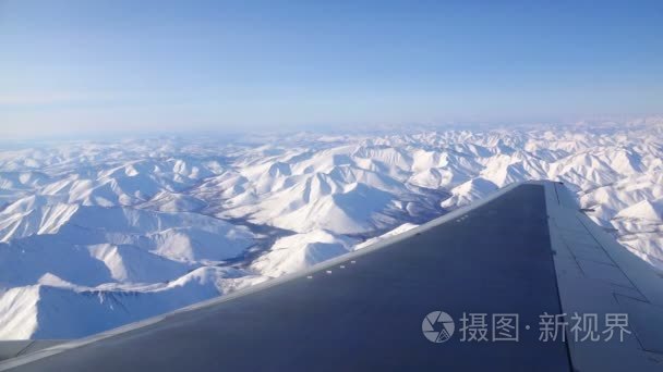 在白天的飞机飞越白雪山和视频