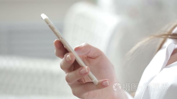 特写的年轻女子手滚动图片电话。上网冲浪