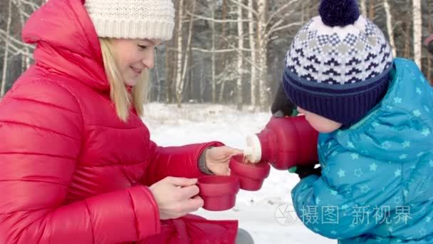 母亲和儿子从热水瓶户外喝茶视频