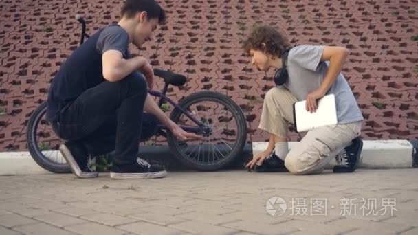 青少年在公园里谈论极端自行车视频